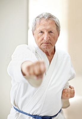 Confident old male trainer practising karate