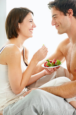 Young couple eating strawberries together
