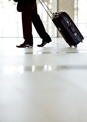 Lower section of a business man walking with travel bag
