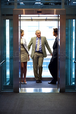 Successful business people standing in office elevator