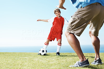 Small kid playing football with his father