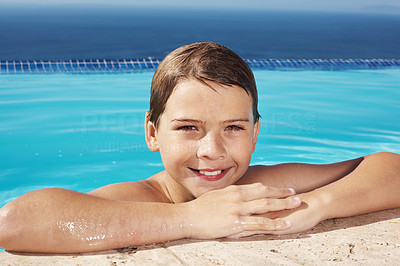 Cute little kid leaning on the side of a swimming pool