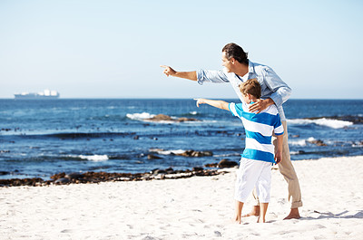 Father and son both pointing at the sea - Copyspace