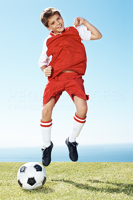 Excited small soccer player jumping in joy