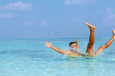 Joyful young guy having fun in water
