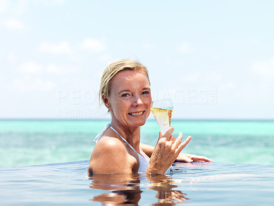 Attractive mature lady in swimming pool with cocktail