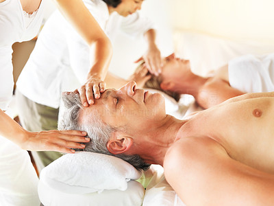 Mature couple receiving a massage in a spa center