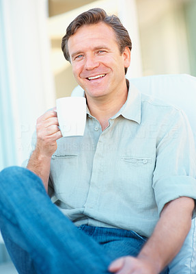 Smiling mature man holding a cup of coffee in hand