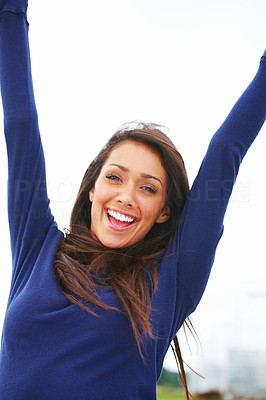 Happy joyful young woman raising hands