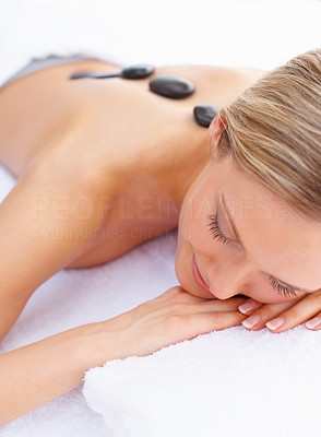 Closeup of a female pampering herself with a stone massage therapy