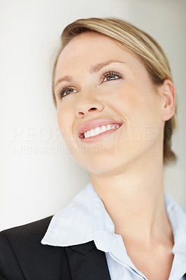 Closeup of a happy pretty young business woman lost in thoughts