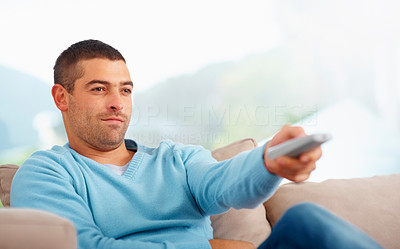 Smart young guy watching television