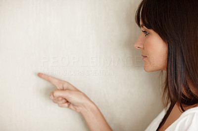 Profile view of a young woman pointing at copyspace