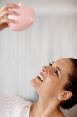 Happy female looking into the piggy bank