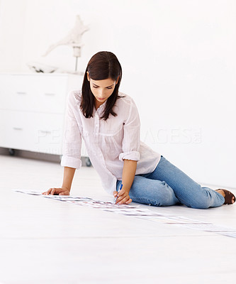 Pretty news paper editor working on photographs while seated on the floor