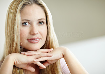 Pretty young woman with hands on chin looking away