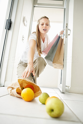 Returning from store - Woman picking up fallen fruits at home