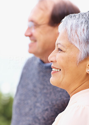Closeup of a elderly woman looking away with husband at the back