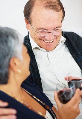 Smiling old couple enjoying a glass of wine