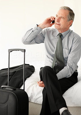Business man sitting on sofa while talking over cell phone