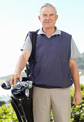 Happy confident mature man carrying golf kit