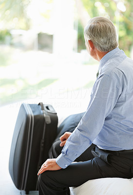 Matured business man sitting on couch with his luggage