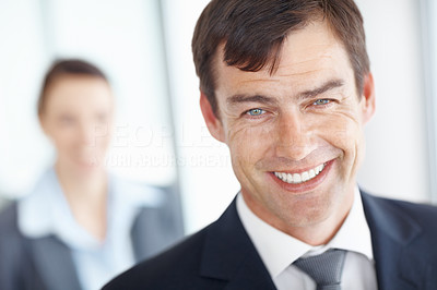 Happy middle aged man with a blurred woman in background