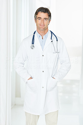 Confident handsome male doctor with hands in pockets