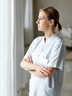 Middle aged nurse day dreaming outside the window
