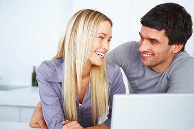 Young couple smiling and looking at each other at home