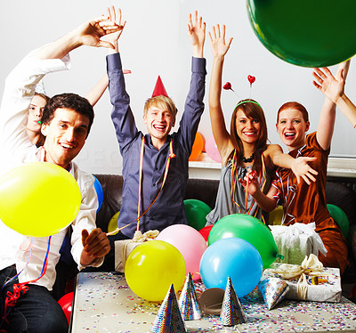 Young people waving hands at a birthday party with balloons
