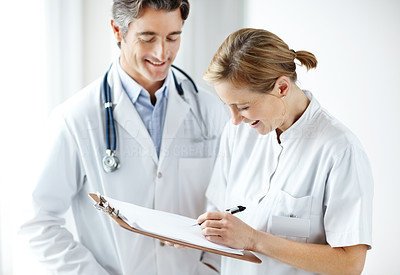 Happy mature medical staff making notes together