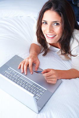 Top view portrait of a beautiful woman lying on bed and using laptop