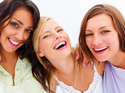 Closeup portrait of smiling young friends standing together against white background