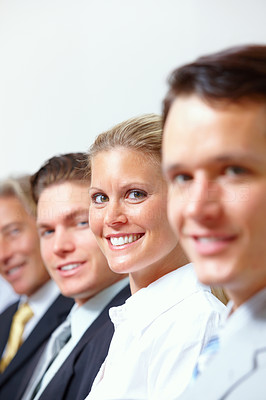Closeup of happy business men and women sitting in a line