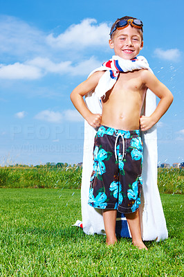 Child standing in garden with a towel