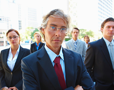 Closeup of a mature business man standing with business team