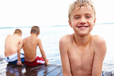 Closeup of a small boy on a deck with friends sitting in background
