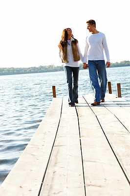 Young boy and girl walking together on a wooden deck