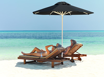 Couple relaxing on beach under umbrella