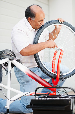 Portrait of a mature man repairing his bike