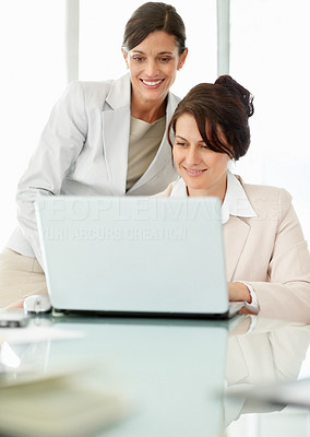 Happy business women working on a laptop at office