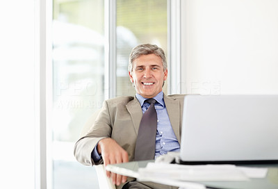 Happy mature business man with laptop at office