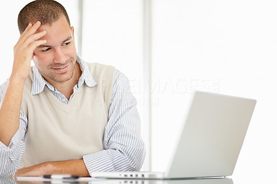 Happy middle aged man smiling while looking at his laptop