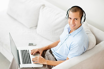 Man wearing headphones while listening to music on the laptop