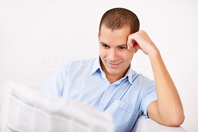 Happy middle aged man reading newspaper against white