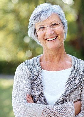 Happy senior woman standing with folded hand