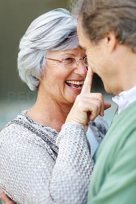 A happy old female with a finger on a man\'s nose