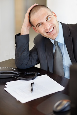 Happy middle age business man with telephone and form on desk