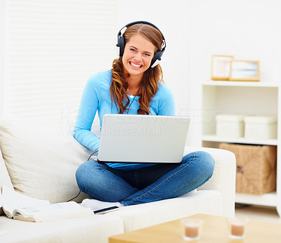 Portrait of a young teen girl enjoying the music on the laptop while at home